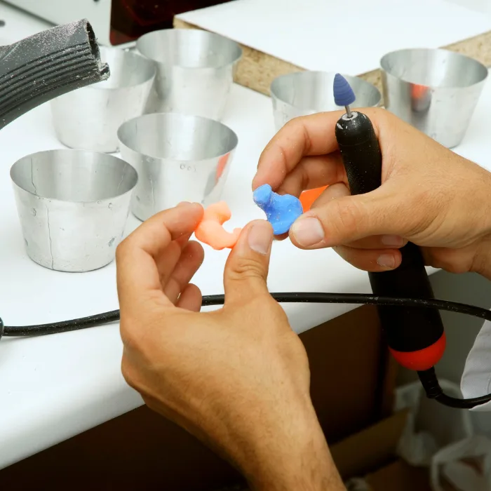 Audiologist carrying out custom ear plug fitting during a clinic appointment